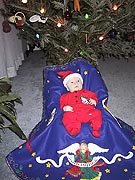 Samuel on tree skirt by cousin Pat 