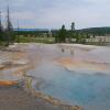Hot spring with Great Fountain Geyser erupting in background