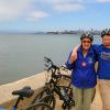 Julia and Sam celebrate successful bike ride over Golden Gate Bridge and back to San Francisco Presidio Beach