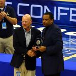 Commissioner Karl Benson presents coach of year trophy to Ron Hunter
