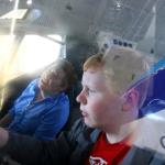 Julia and Sam sit in the cockpit of 727 with reflection of Eastern Airlines 727 parked next to the cockpit simulator at Future of Flight Museum, July 6, 2014