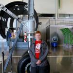 Sam stands next to front landing gear of new 787 DreamLiner at Future of Flight Museum, July 6, 2014